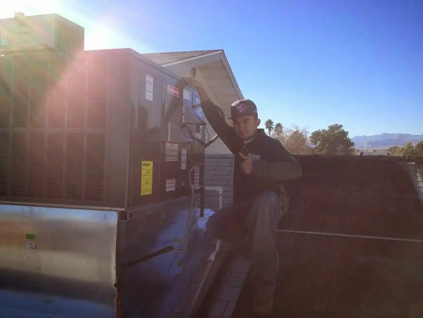 HVAC technician performing Boiler Repair on a rooftop unit in Oak Park
